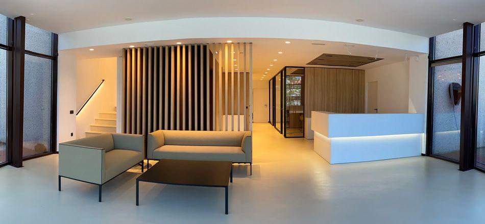 Recepción corporativa con pavimento continuo DECOPOX y lamas de madera