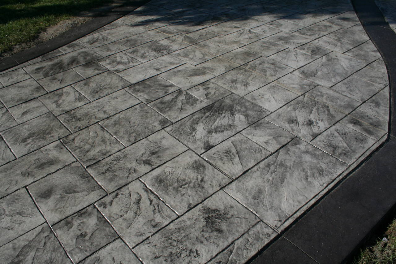 Hormigón impreso con textura de losa de piedra en acceso exterior