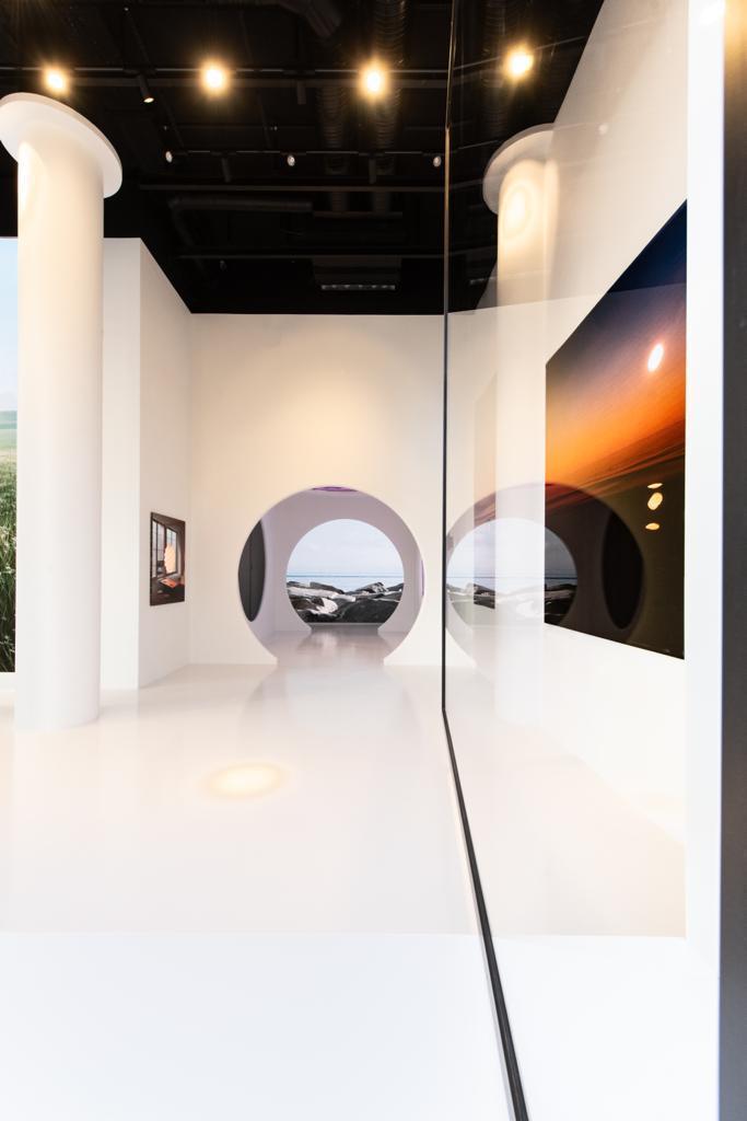 DecopoX — interior de galería con portal circular, columnas blancas y pavimento continuo