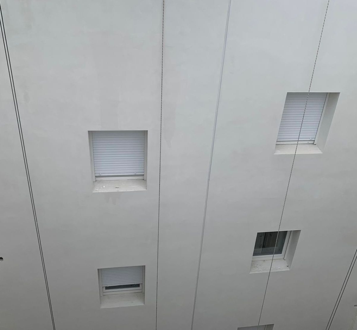 Detalle de fachada terminada con sistema SATE blanco en Casería Aguirre
